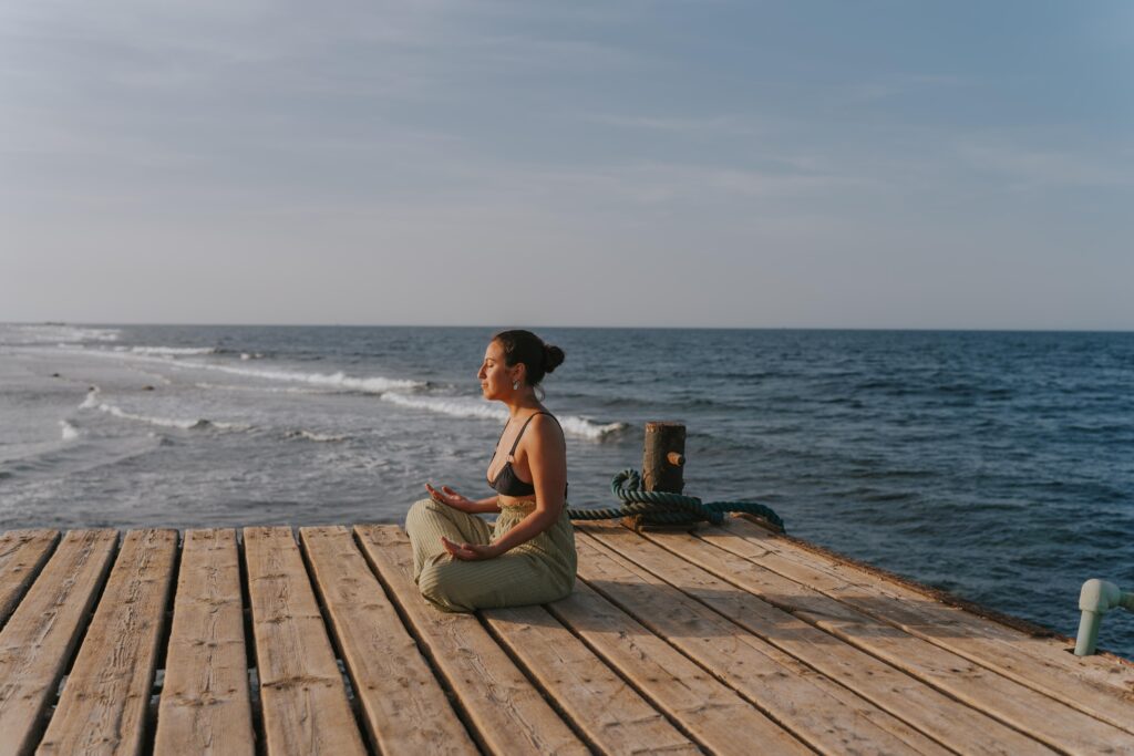 woman-meditating-on-pier-at-golden-hour-embracing-2025-07-27-18-54-16-utc